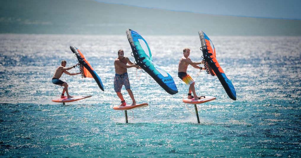Trois hommes en wingfoil guadeloupe avec leur wing